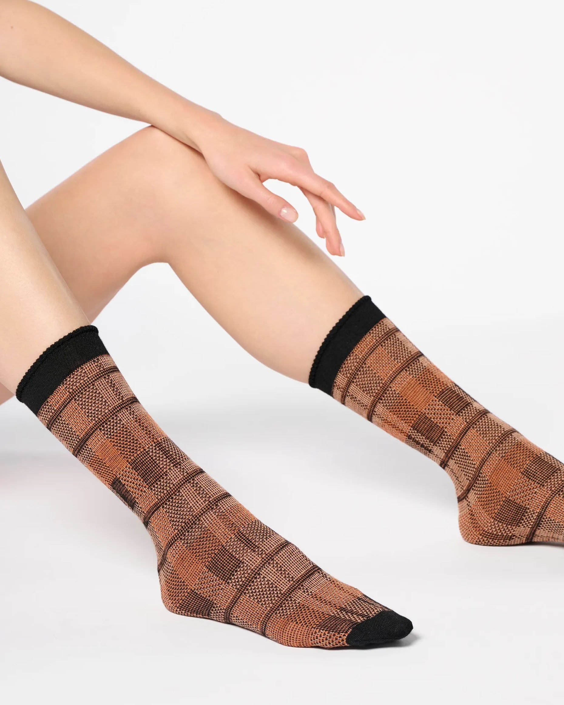 Rust orange ankle socks with a large tartan pattern, black toe and cuff.