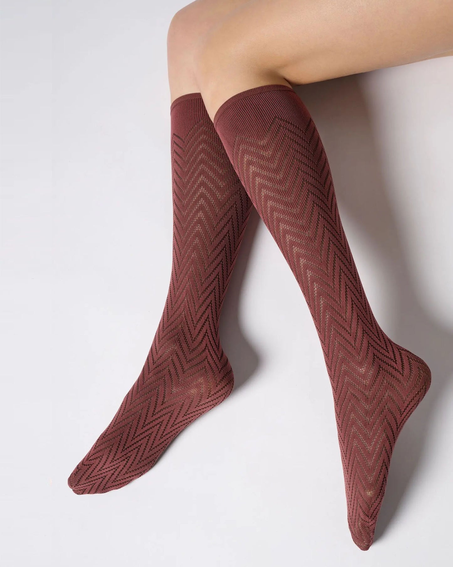 Maroon / brick red opaque knee-high socks with a geometric chevron pattern.