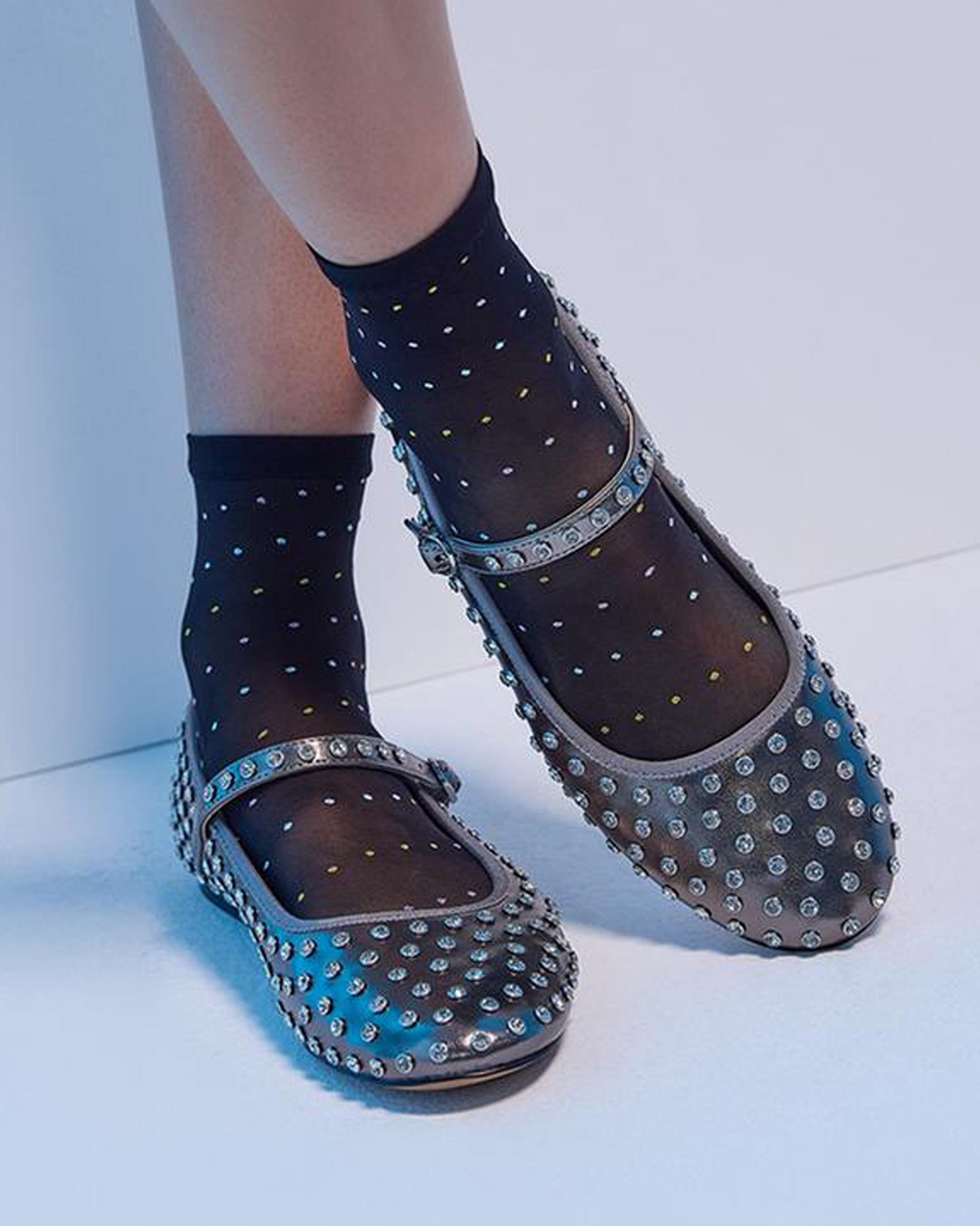 Studded flats with black polka dot socks on a light background