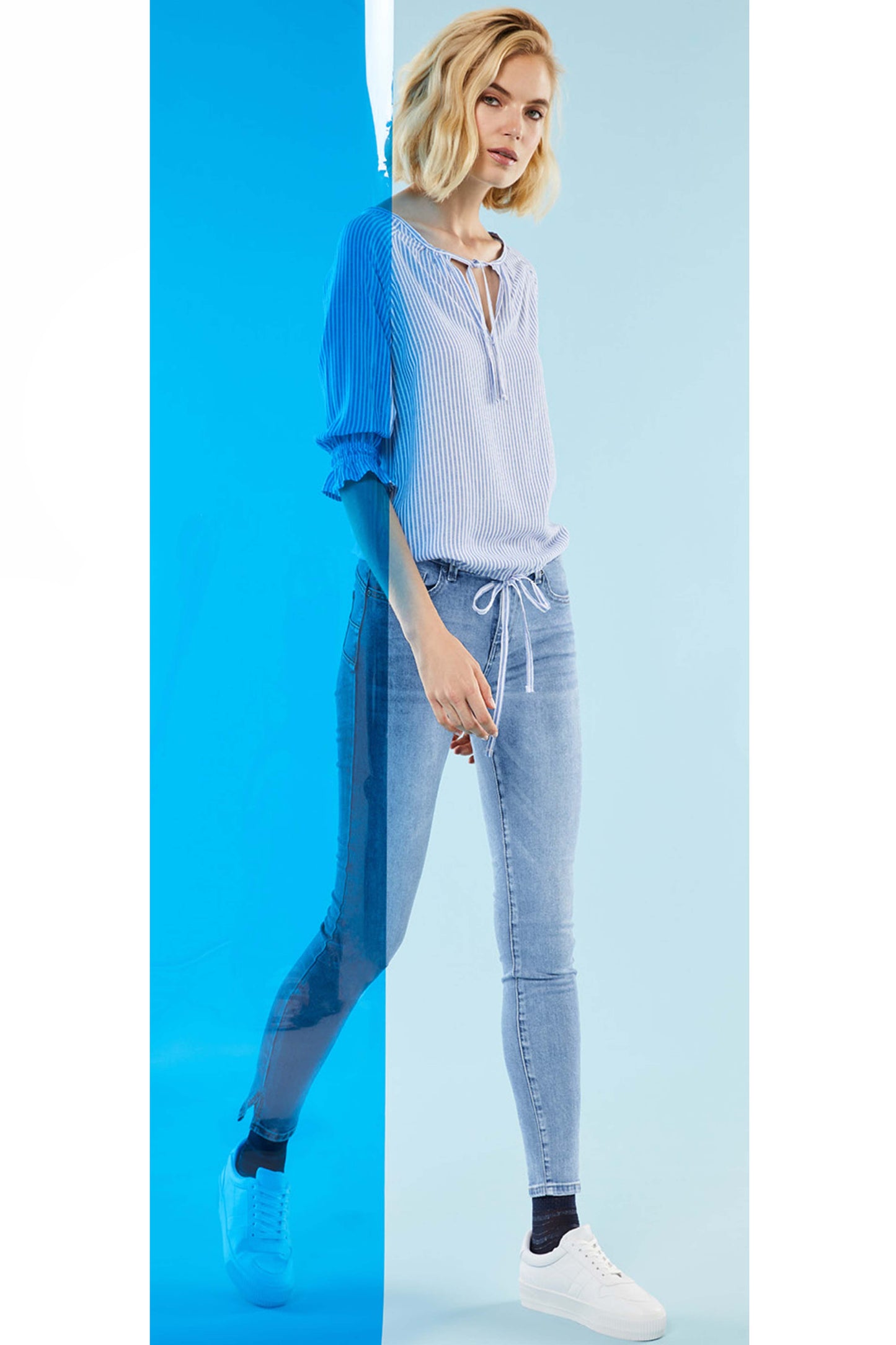 SiSi Look Me Jeggings - High rise soft cotton jean leggings (jeggings) in light denim blue with button and fly zip closures, front and back pockets, belt loops and side slits on the cuffs. Worn with a stripe cotton blouse and white sneakers.