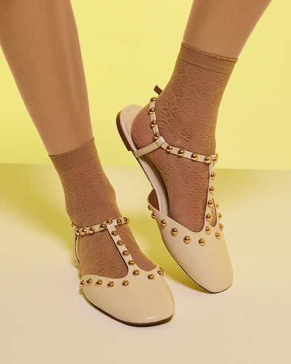 Sheer beige micro mesh fashion ankle socks with a circular floral style pattern, plain cuff with a sparkly silver edge, worn with a cream studded shoe.