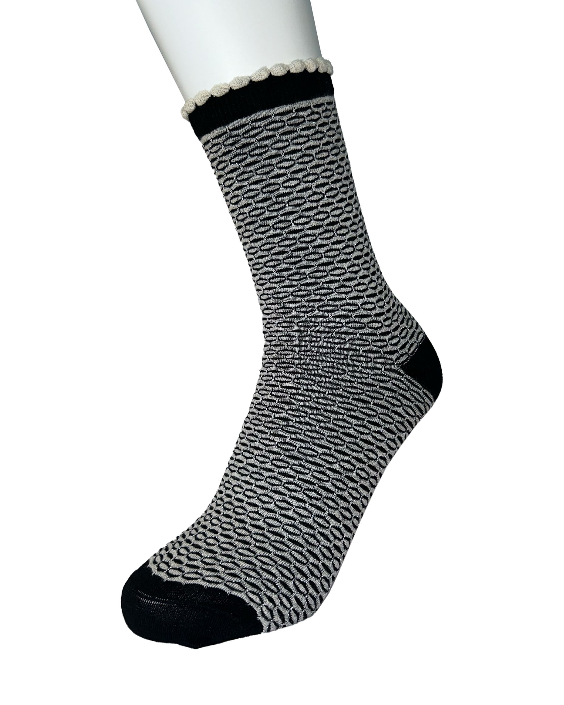 Black and white patterned sock on a mannequin foot against a white background