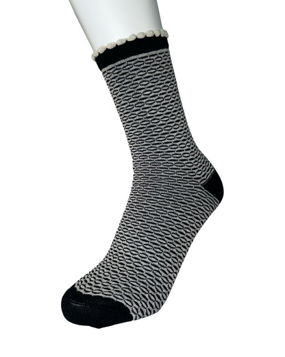 Black and white patterned sock on a mannequin foot against a white background