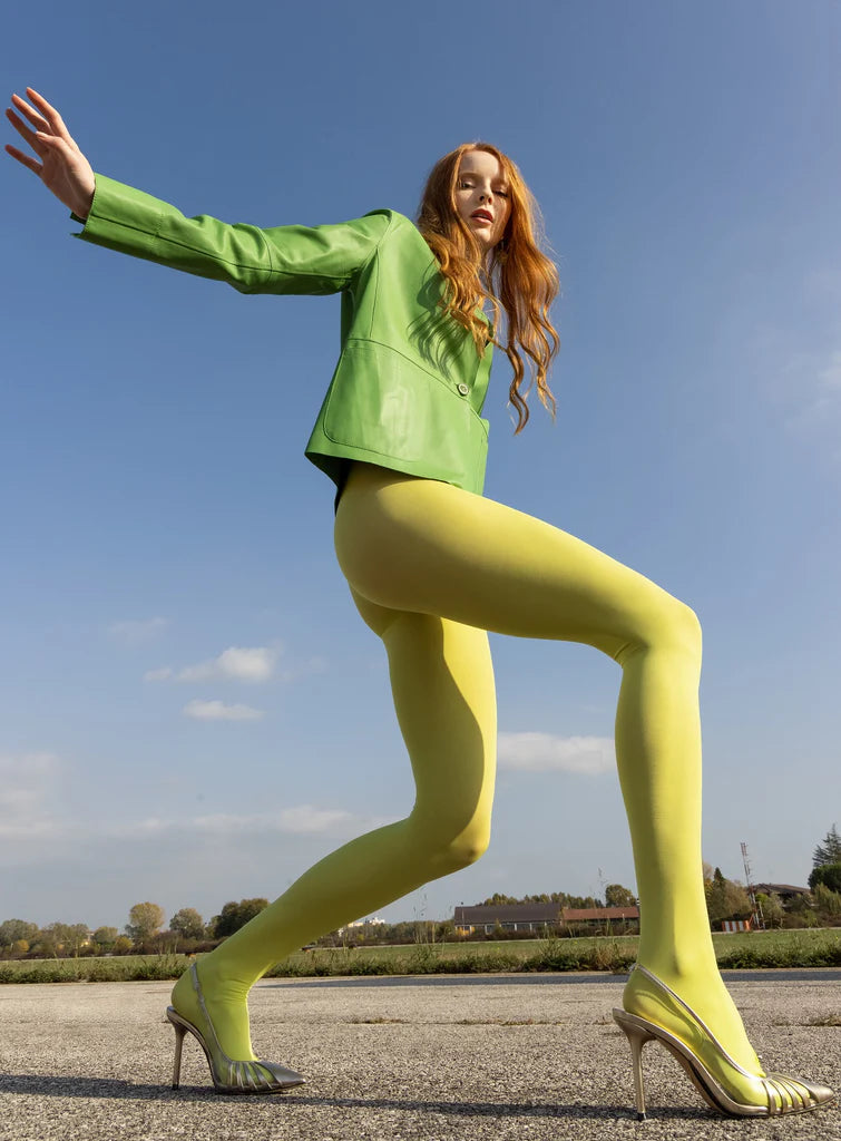 Trasparenze Sophie 70 Collant - coloured opaque tights in bright lime green (citron), worn by a red haired model with light green leather jacket and silver high heels.