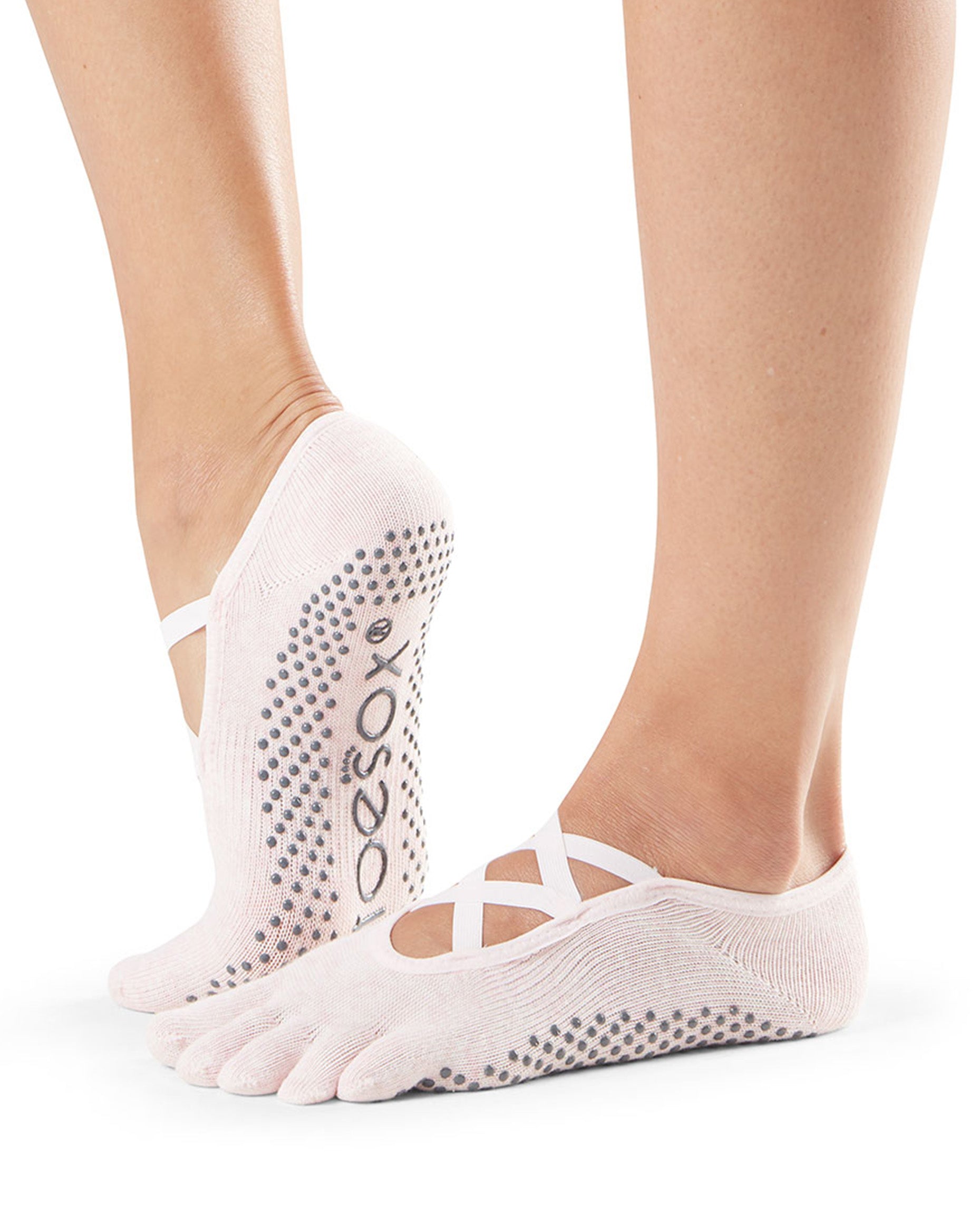 Pale pink five-finger socks with grip dots worn by a person on a white background