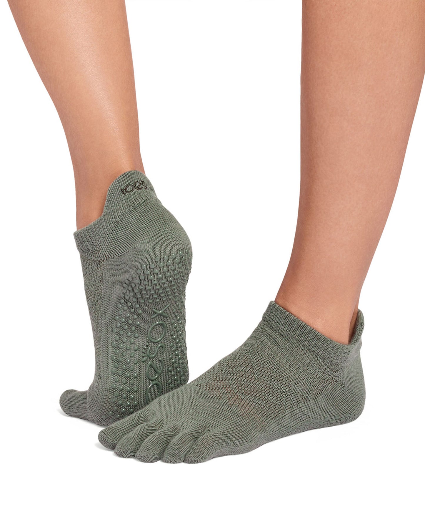 Green five-toe socks with textured soles on a white background
