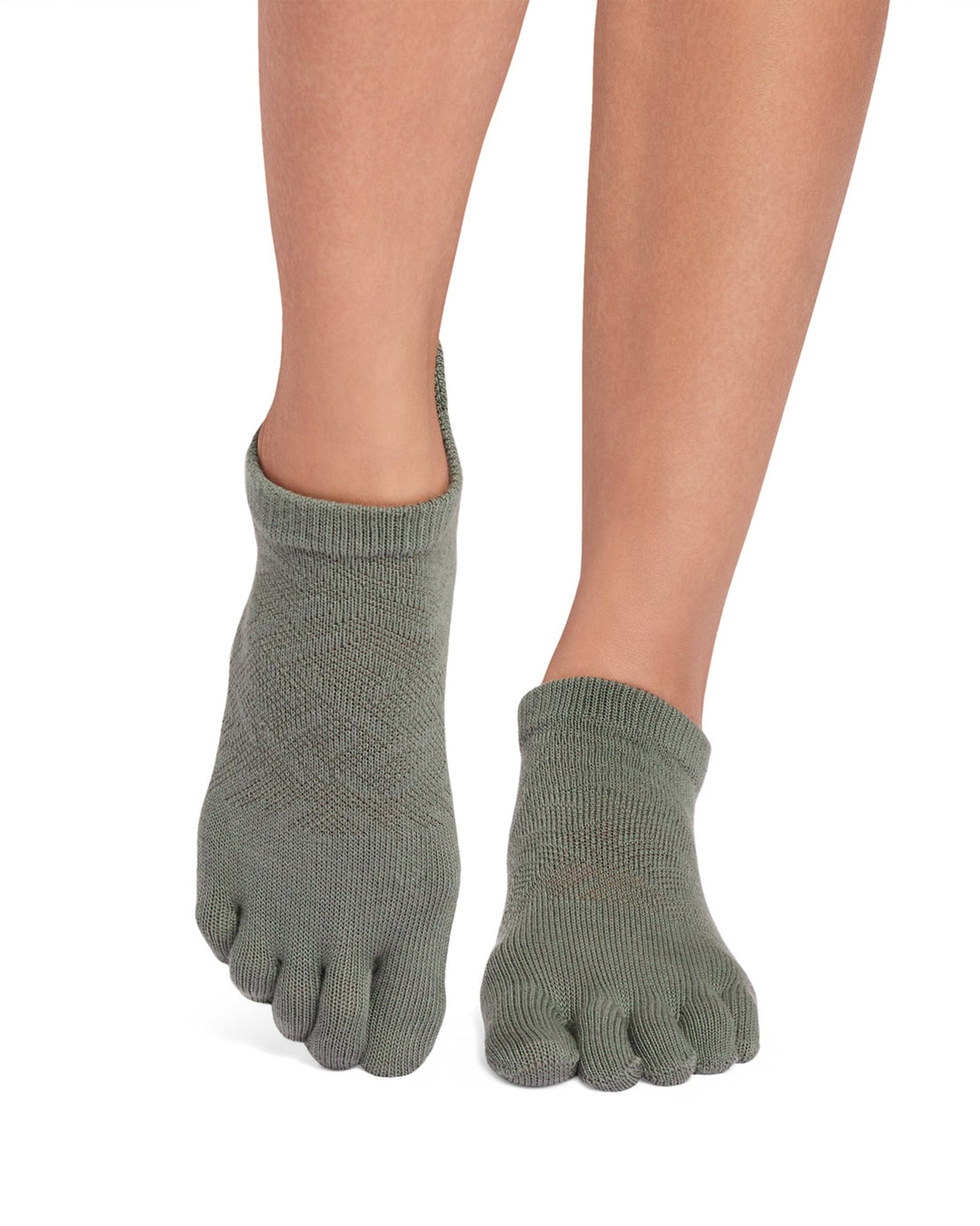 Green toe-separated socks worn on a white background