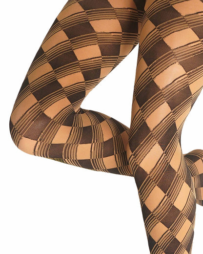 Close-up of a person's legs wearing opaque patterned tights with a black and tan checkerboard and diagonal stripe design, shown against a plain white background.