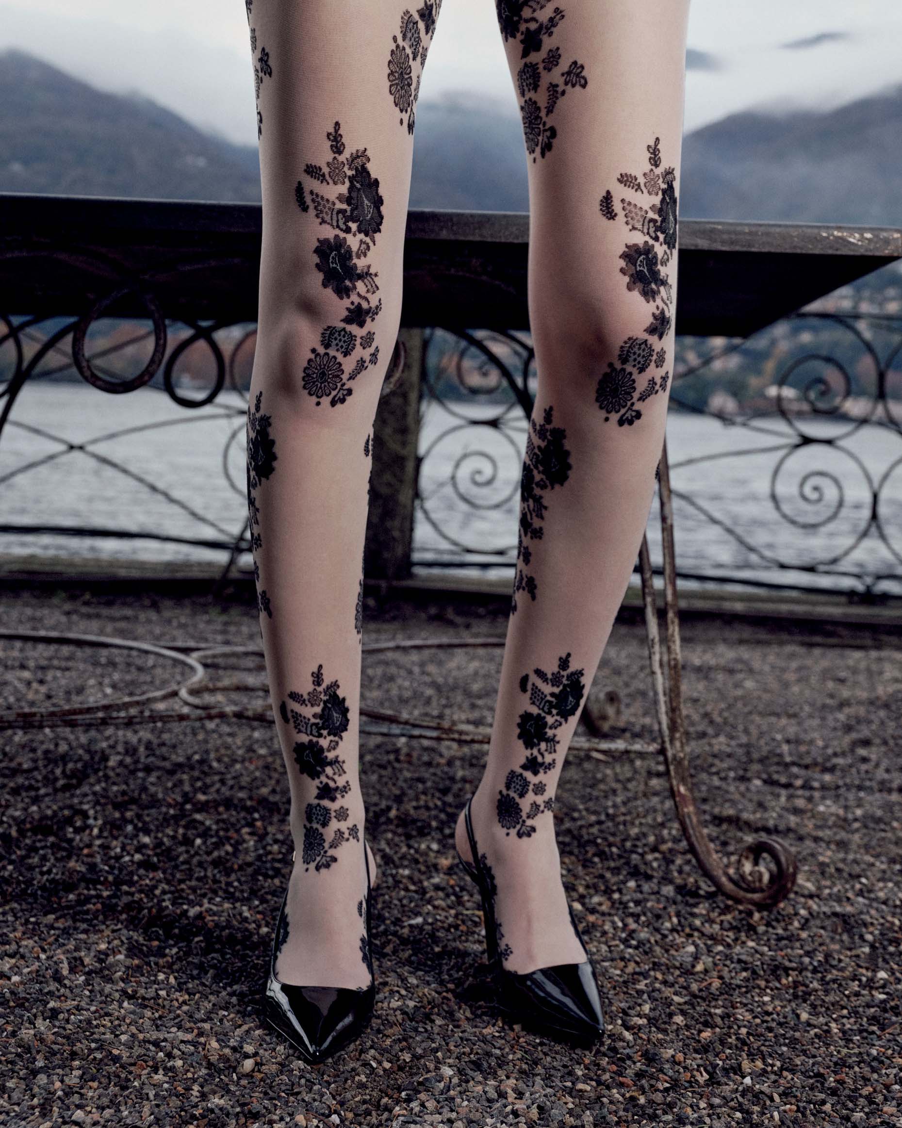 Legs wearing floral-patterned tights with a scenic background