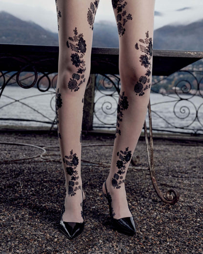 Legs wearing floral-patterned tights with a scenic background