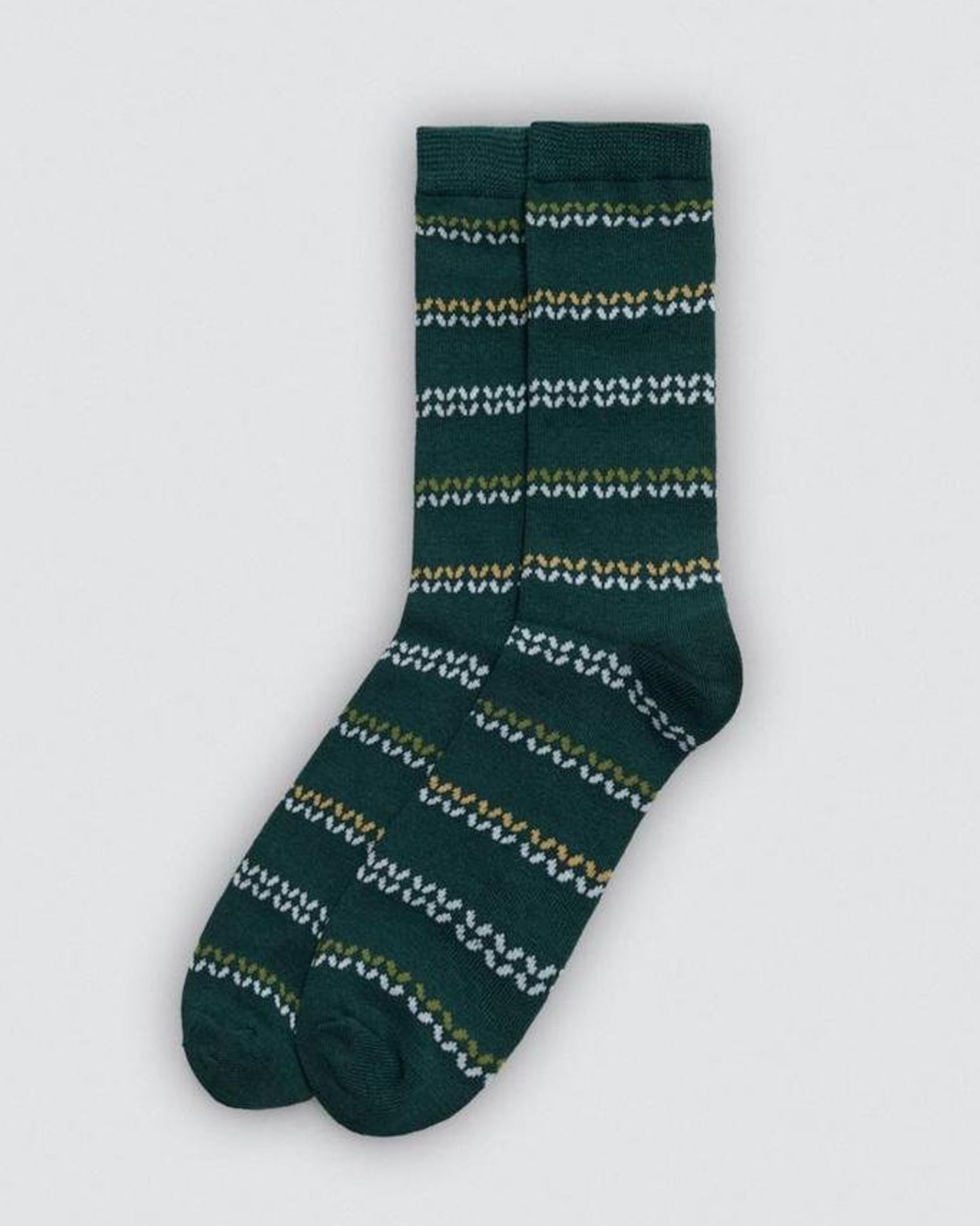 Green sock with white and yellow pattern on a light grey background