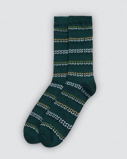 Green sock with white and yellow pattern on a light grey background