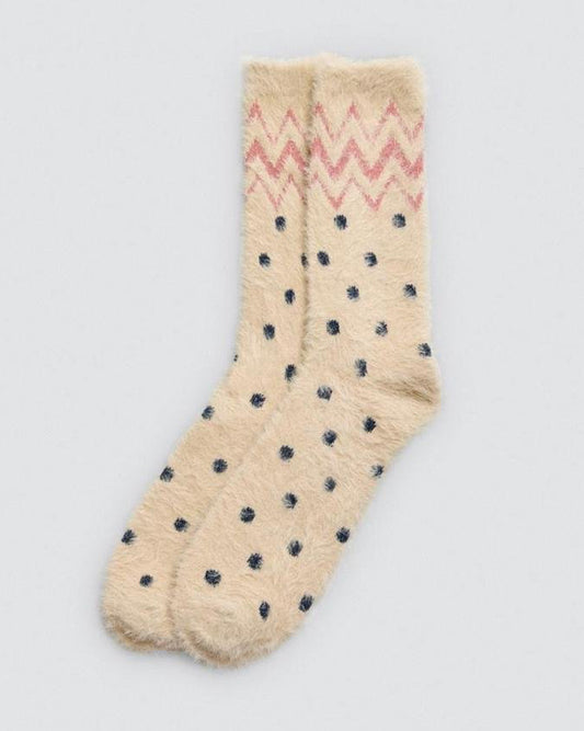 Pale yellow sock with navy polka dots and light pink zigzag pattern on a light grey background