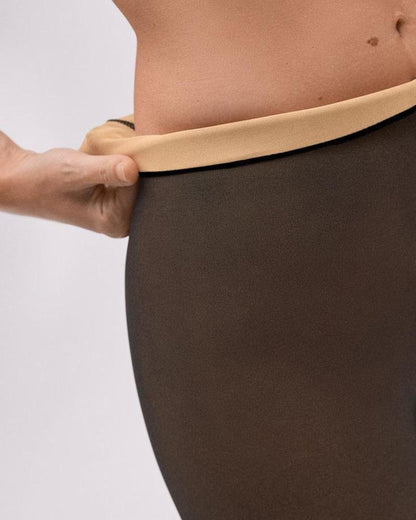 Brown opaque tights with nude on inside, worn by a person on a white background