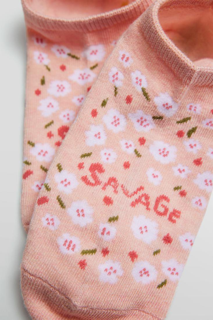 Ysabel Mora 12861 Savage Liners - Light pink cotton low ankle sneaker socks with an all over floral pattern in white and pink and "savage" written across the foot in pink.